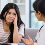 Indian teenage girl discussing puberty in girls with a gynaecologist.